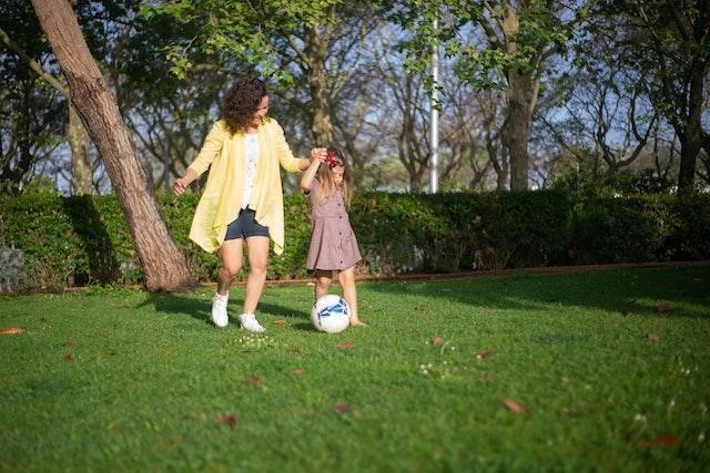 A mother and daughter playing outside.