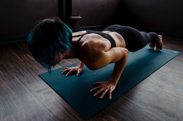Woman doing push-ups on a green mat