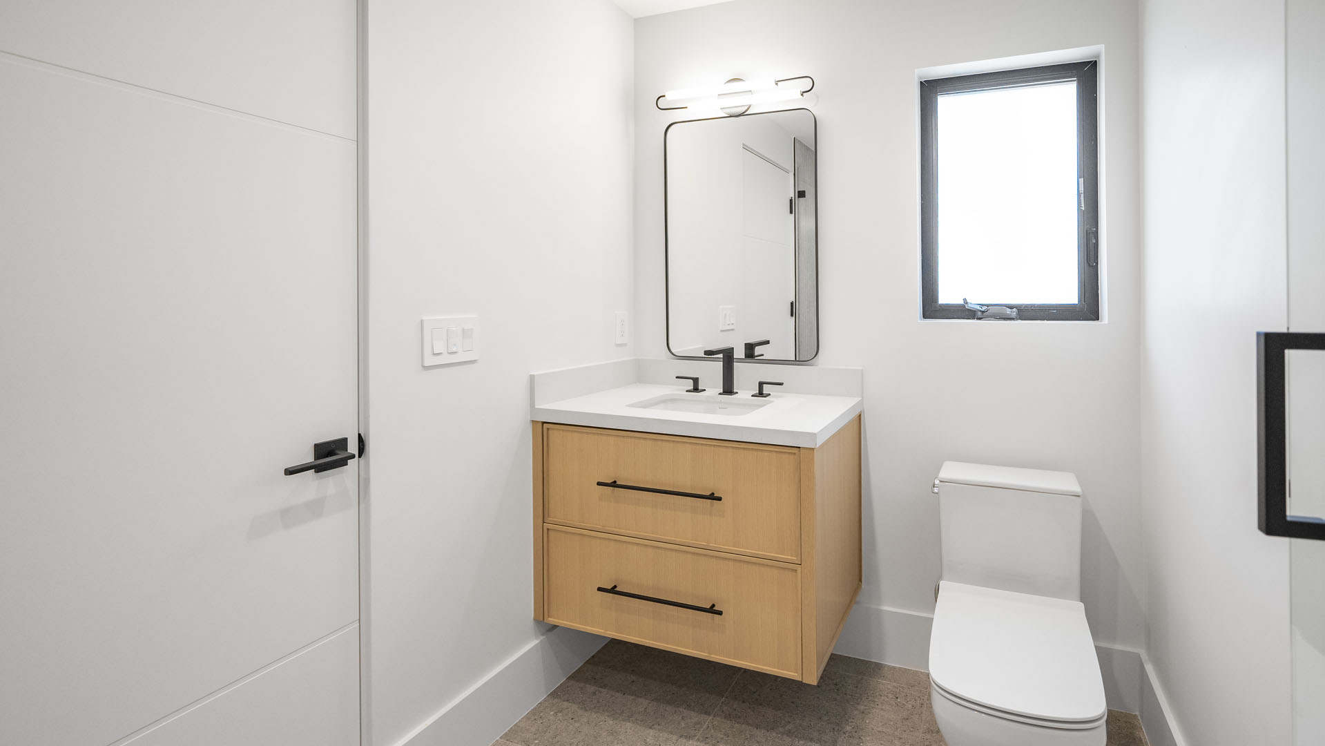 Batroom with toilet, sink, and vanity mirror